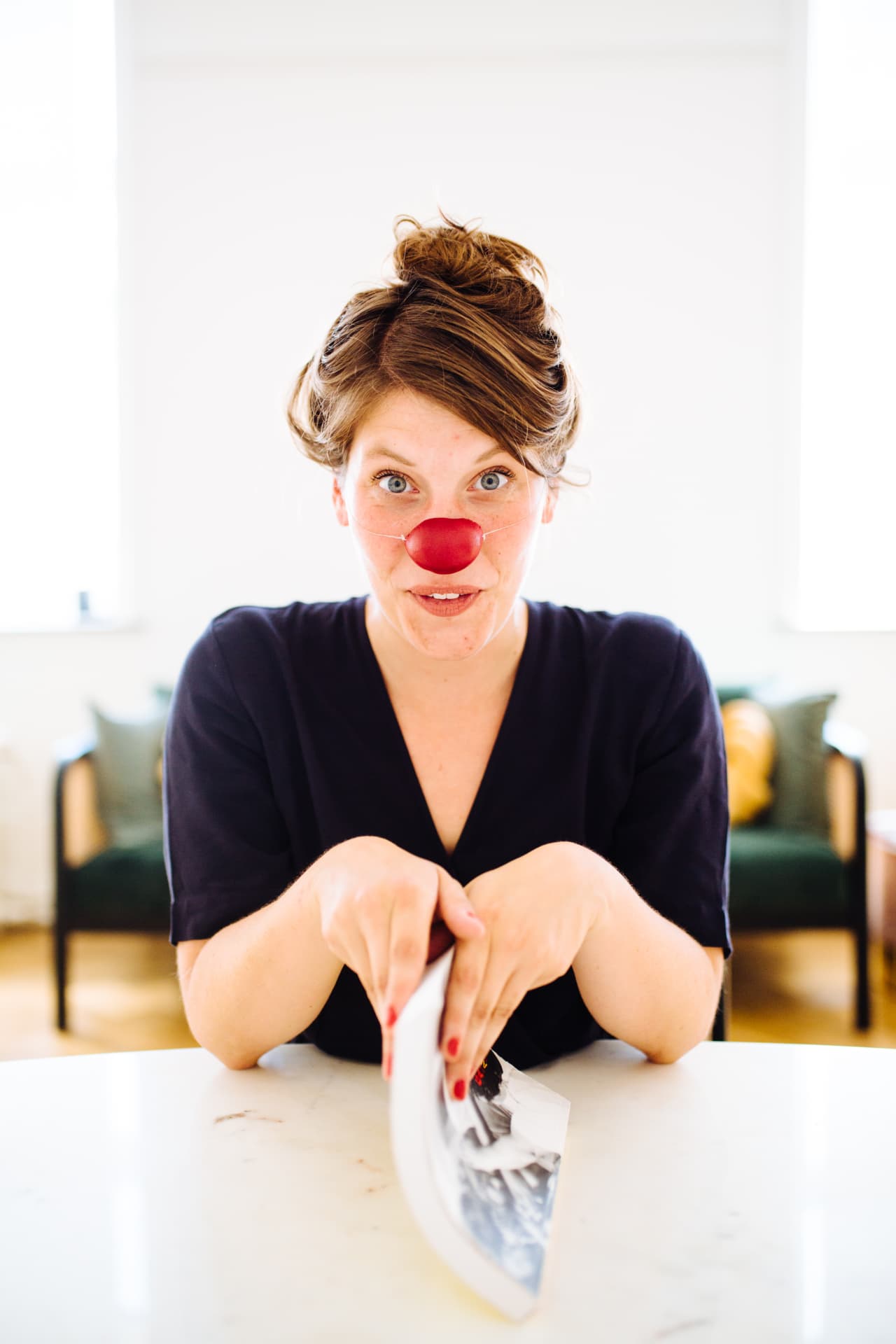 Tessa met een rode clownsneus aan tafel